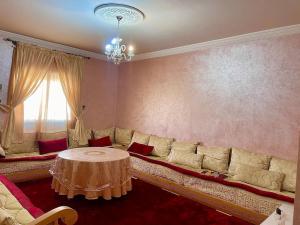 ein Wohnzimmer mit einem Sofa und einem Tisch in der Unterkunft Appartement en résidence (shahid,clim,wifi…) in Marrakesch