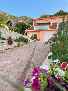 a brick driveway with flowers in front of a house at Apartments Enigma in Mostar