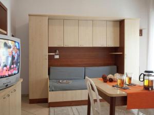 a kitchen with a dining table and a television at Vibrant Apartment in Rimini with Balcony in Rimini