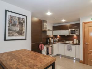 a kitchen with white cabinets and a wooden table at 5 St Mary's Church in Moffat