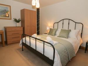 ein Schlafzimmer mit einem großen Bett und einer Kommode in der Unterkunft 5 St Mary's Church in Moffat