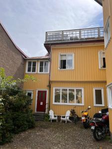 a yellow house with motorcycles parked in front of it at lägenhet på innergården in Alingsås