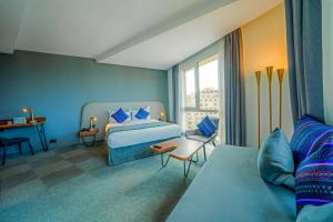 Kyriad Residence Casablanca في الدار البيضاء: غرفة زرقاء مع سرير وأريكة