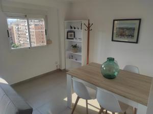 een eetkamer met een houten tafel en stoelen bij Apartamento Campoamor in Castellón de la Plana