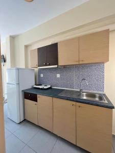 an empty kitchen with a sink and a refrigerator at Rooms Elena in Nea Potidaea