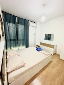 ein Schlafzimmer mit einem Bett und einem großen Fenster in der Unterkunft Lake Escape - Home 2 in Tirana