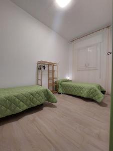 マルサラにあるCasa Antonellaの緑のベッド2台が備わる部屋