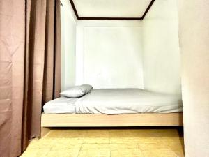 a small bed in a room with a window at Transient Home at Tierra Vista near SM Dasma with Wifi and Netflix in Mabatang