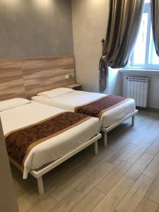 2 camas en una habitación con suelo de madera en B&B Drago D'Oro - Metro piazza Vittorio Emanuele II, en Roma