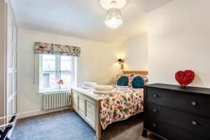 1 dormitorio con cama y ventana en Woodside Cottage, Congleton, Nr Peak District en Congleton