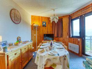 une salle à manger avec une table et un chiffon de table blanc dans l'établissement Apartment Ariane-3 by Interhome, au Corbier