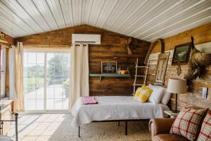 una camera con letto e parete in legno di Molitor Milk House- Feathered Acres Learning Farm & Inn a Belgrade