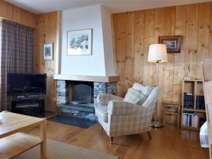 a living room with a fireplace and a tv at Apartment Andrea A-B by Interhome in Crans-Montana