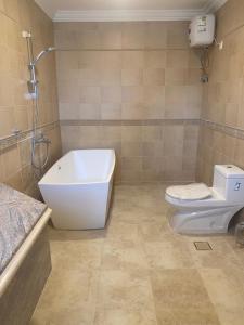 La salle de bains est pourvue de toilettes, d'une baignoire et d'un lavabo. dans l'établissement ليالي الخالدية, à Riyad