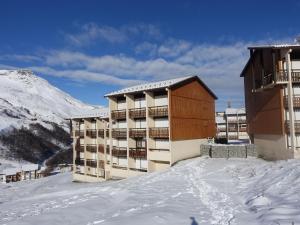 un gran edificio en la nieve con una montaña en Apartment Les Asters-15 by Interhome, en Les Menuires