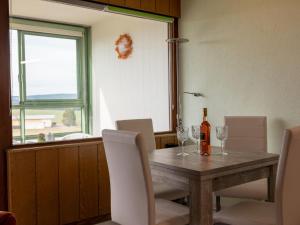 ein Esszimmer mit einem Tisch und einer Flasche Wein in der Unterkunft Apartment G 25 by Interhome in Dittishausen