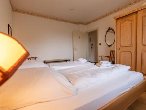 two white beds in a room with a lamp at Holiday Home Sonnenbühl by Interhome in Dittishausen