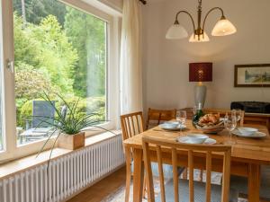 une salle à manger avec une table et une grande fenêtre dans l'établissement Holiday Home Sonnenbühl by Interhome, à Dittishausen