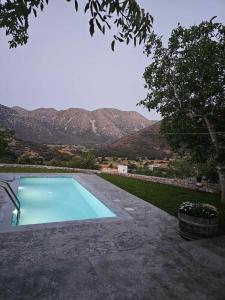 a blue swimming pool with mountains in the background at Patriko-Cozy villa on the foot of the mountains in Ammoudari