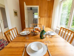 een houten tafel met een bord eten en wijnglazen bij Holiday Home Sonnenbühl by Interhome in Dittishausen