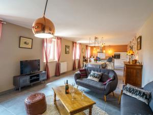 ein Wohnzimmer mit einem Sofa und einem Tisch in der Unterkunft Holiday Home Les Volets Rouges - PEU101 by Interhome in Peumérit
