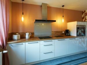 eine Küche mit weißen Schränken und einer Arbeitsplatte in der Unterkunft Holiday Home Les Volets Rouges - PEU101 by Interhome in Peumérit