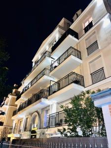 a white building with balconies at night at LES RÉSIDENCES DE DJIBRIL in Le Blanc-Mesnil