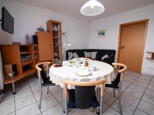 a dining room with a white table and chairs at Apartment Frisiastrasse-1 by Interhome in Norddeich