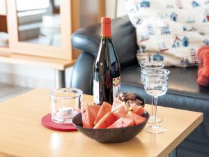 a bottle of wine and a bowl of fruit on a table at Apartment Frisiastrasse-1 by Interhome in Norddeich