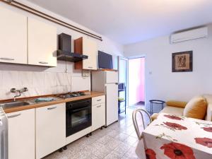 een keuken met witte kasten en een tafel in een kamer bij Apartment Romantika-2 by Interhome in Štanga