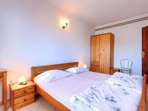 een slaapkamer met een groot bed en een houten kast bij Apartment Romantika-2 by Interhome in Štanga