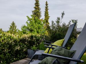 a rocking chair on a patio with trees and bushes at Holiday Home Hochwald by Interhome in Dittishausen