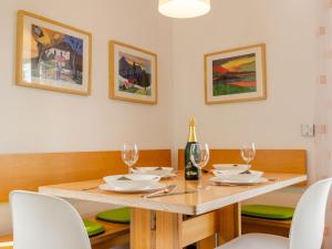 una sala da pranzo con tavolo, sedie e una bottiglia di vino di Holiday Home Hochwald by Interhome a Dittishausen