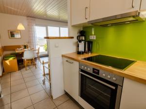 eine Küche mit grünen Wänden und einem Herd Top-Backofen in der Unterkunft Holiday Home Hochwald by Interhome in Dittishausen