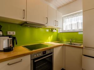 a green kitchen with a sink and a stove at Holiday Home Hochwald by Interhome in Dittishausen