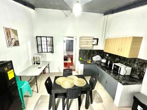 a kitchen with a table and chairs in a room at Transient Home at Tierra Vista near SM Dasma with Wifi and Netflix in Mabatang