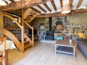 uma sala de estar com lareira de pedra e escadas em Holiday Home Au Verger Fleuri - HUD400 by Interhome em Hudimesnil