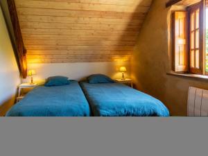 duas camas num pequeno quarto com duas janelas em Holiday Home Au Verger Fleuri - HUD400 by Interhome em Hudimesnil