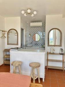 a kitchen with two mirrors and a counter with two stools at Mont Astral in Monchique