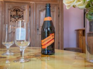 uma garrafa de vinho sentada numa mesa com dois copos em Holiday Home Les Azalées - PML103 by Interhome em Ploumilliau