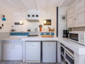 una cucina con armadi bianchi e piano di lavoro di Holiday Home Entre mer et jardin - PPT401 by Interhome a Saint-Pierre-en-Port