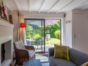 ein Wohnzimmer mit einem Sofa und Stühlen sowie eine Terrasse in der Unterkunft Holiday Home Entre mer et jardin - PPT401 by Interhome in Saint-Pierre-en-Port