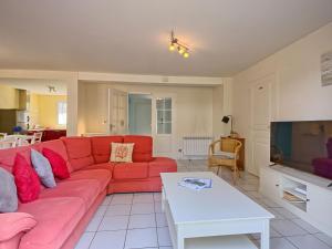 a living room with a red couch and a tv at Holiday Home Ar Mimoza - LBO301 by Interhome in Le Bono