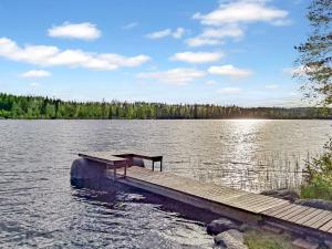 a dock on a lake with a bench on it at Holiday Home Honkakoti by Interhome in Kurkimaki