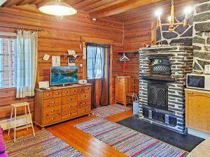 een woonkamer met een open haard en een televisie bij Holiday Home Honkakoti by Interhome in Kurkimaki