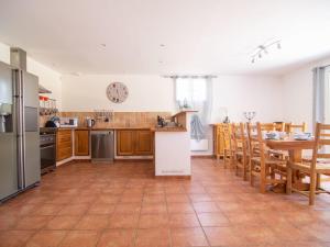 CarcèsにあるHoliday Home Les Restanques - CAE150 by Interhomeのキッチン(木製キャビネット、テーブル、テーブル、椅子付)