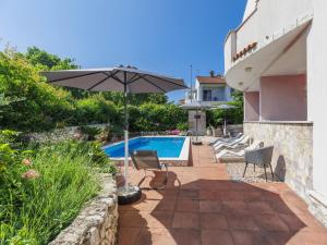 een patio met een parasol en een zwembad bij Apartment Romantika-2 by Interhome in Rovinj