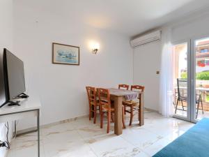 een eetkamer met een tafel, stoelen en een televisie bij Apartment Romantika-3 by Interhome in Rovinj