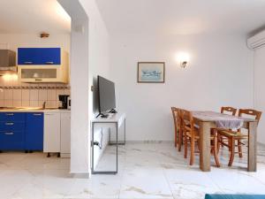 een keuken en eetkamer met een tafel en een televisie bij Apartment Romantika-3 by Interhome in Rovinj