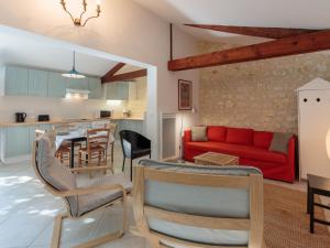 een woonkamer met een rode bank en een keuken bij Holiday Home Domremy by Interhome in Saint-Palais-sur-Mer